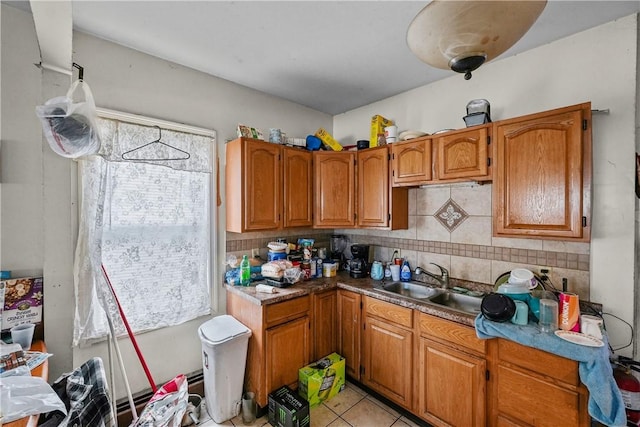 kitchen featuring sink, a healthy amount of sunlight, backsplash, and light tile patterned floors