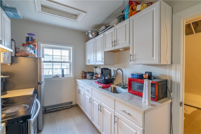 kitchen with sink, light hardwood / wood-style flooring, white cabinetry, light stone counters, and range