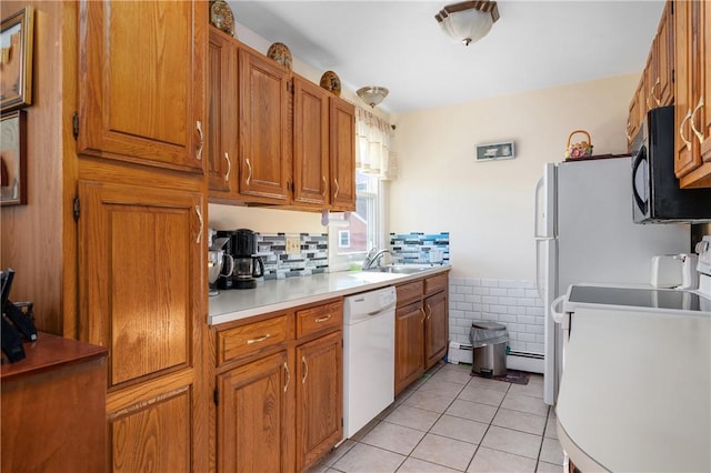 kitchen featuring white appliances, sink, and light tile patterned floors