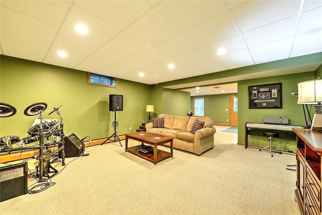 carpeted living room featuring a drop ceiling and a baseboard heating unit