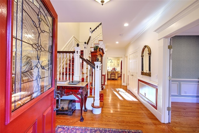 foyer entrance featuring hardwood / wood-style floors and ornamental molding