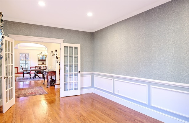 unfurnished room with french doors, hardwood / wood-style flooring, and ornamental molding