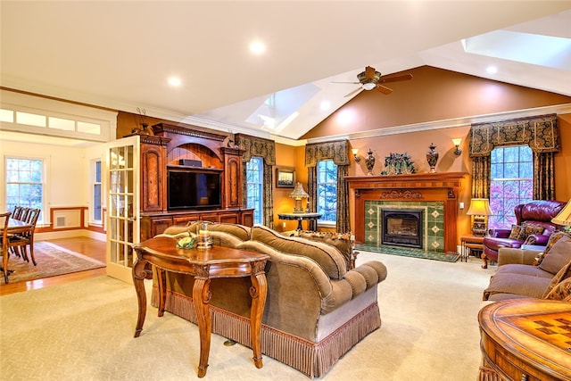 living room with a healthy amount of sunlight, ornamental molding, light hardwood / wood-style flooring, and a skylight