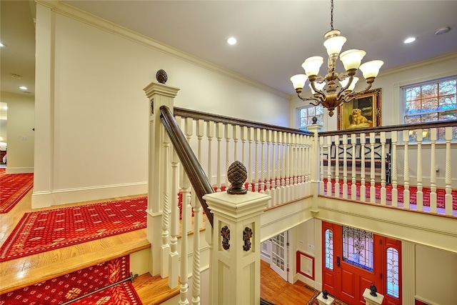 stairs with crown molding and a chandelier