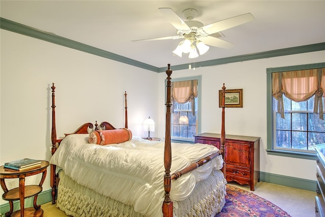 bedroom with ceiling fan, ornamental molding, light carpet, and multiple windows