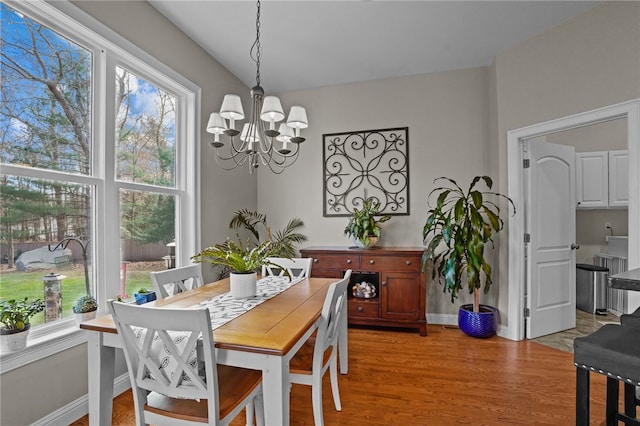 dining area with an inviting chandelier and light hardwood / wood-style flooring