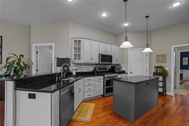 kitchen with pendant lighting, a center island, dark wood-type flooring, sink, and stainless steel appliances