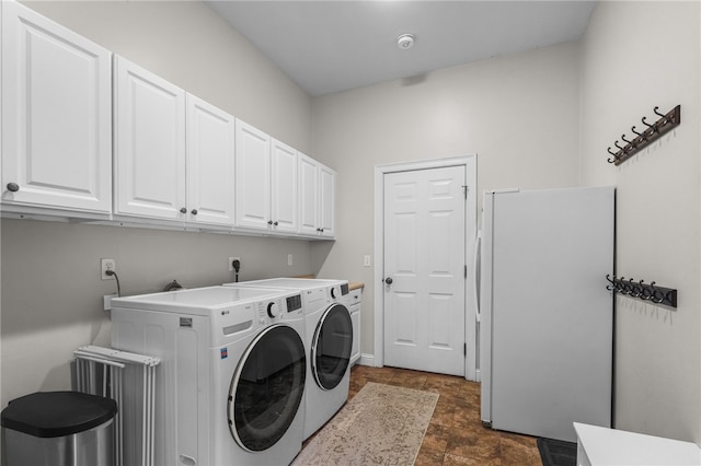 laundry room featuring washer and clothes dryer and cabinets