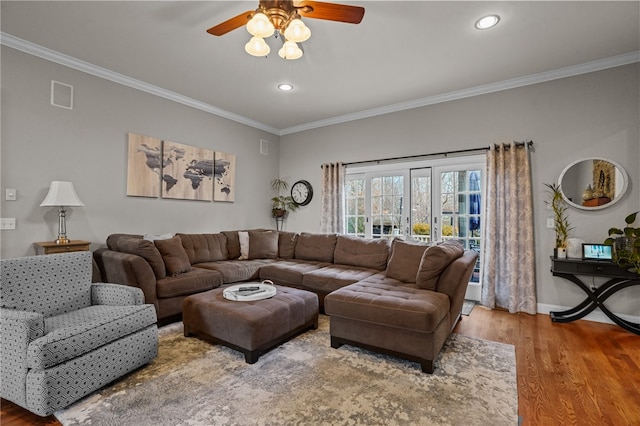 living room featuring hardwood / wood-style flooring, ceiling fan, and crown molding