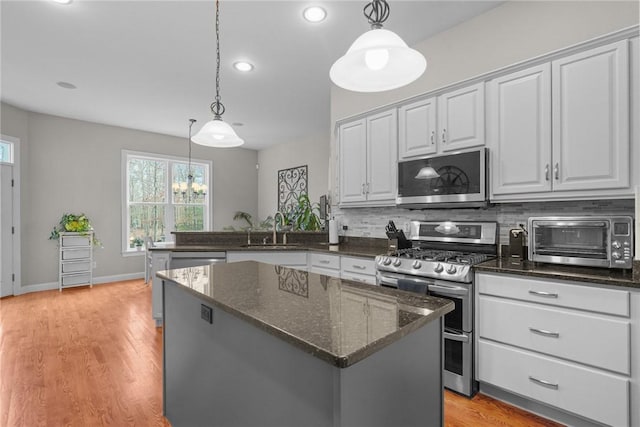 kitchen featuring pendant lighting, stainless steel appliances, and dark stone countertops