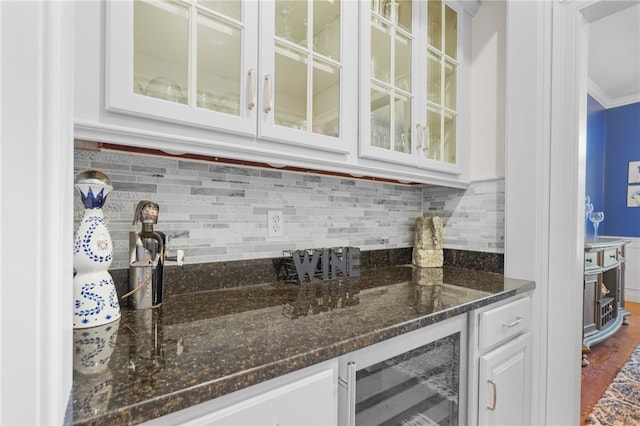 bar with crown molding, wood-type flooring, dark stone countertops, white cabinets, and wine cooler