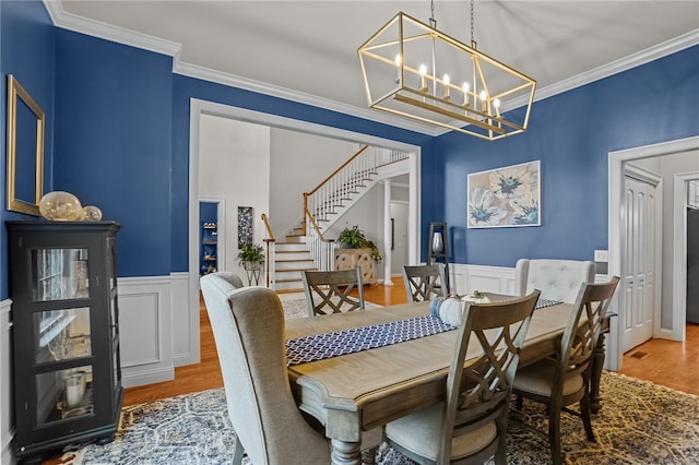 dining room featuring hardwood / wood-style floors, crown molding, and a notable chandelier