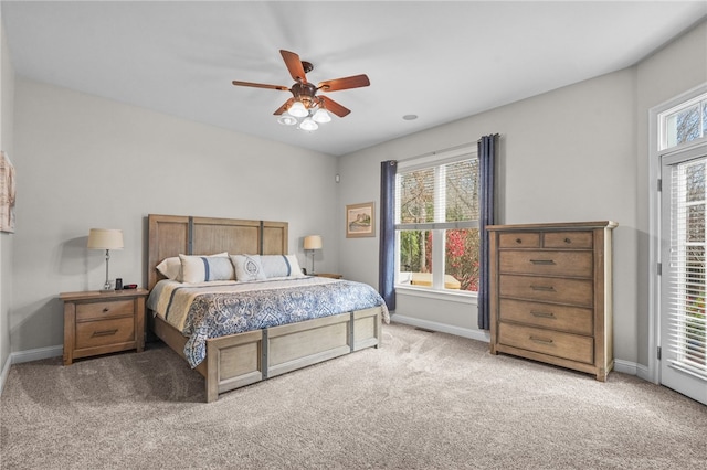 carpeted bedroom featuring ceiling fan and multiple windows