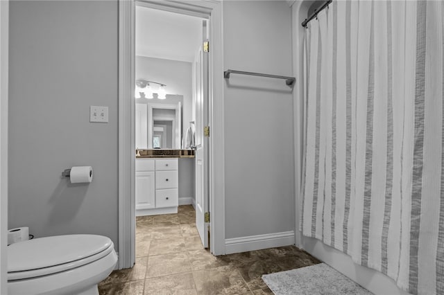 bathroom with walk in shower, vanity, and toilet