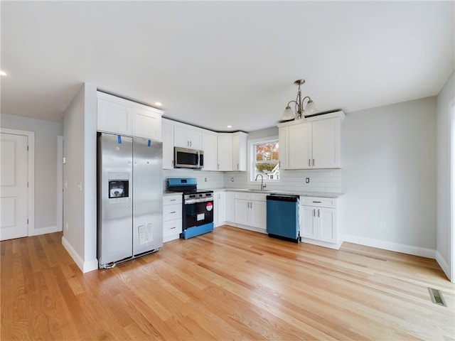 kitchen featuring sink, white cabinets, light wood-type flooring, and appliances with stainless steel finishes