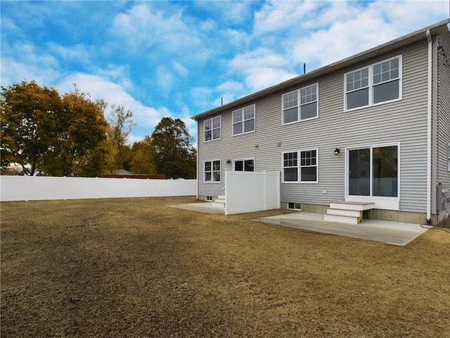 rear view of house with a lawn and a patio