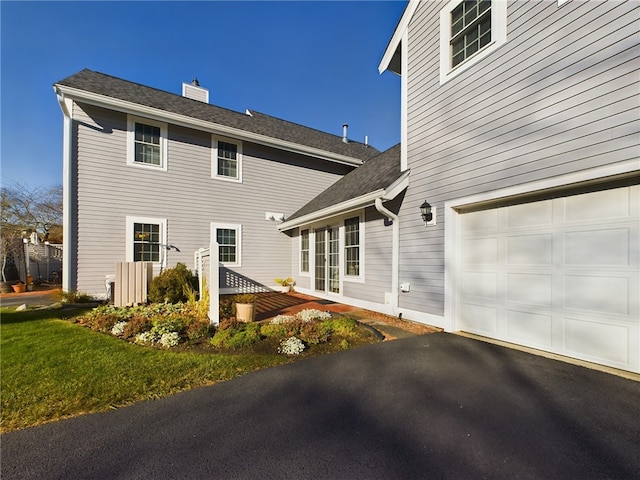 rear view of property featuring a garage