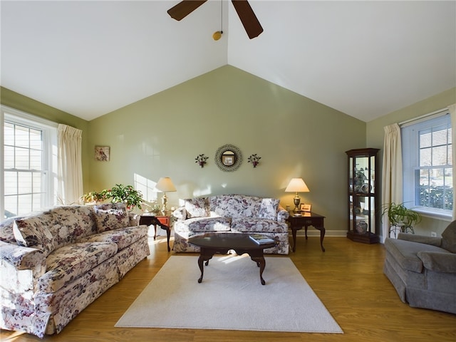 living room with hardwood / wood-style floors, high vaulted ceiling, ceiling fan, and a healthy amount of sunlight