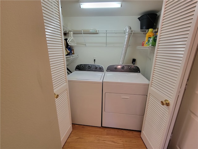 laundry area featuring separate washer and dryer and light hardwood / wood-style floors