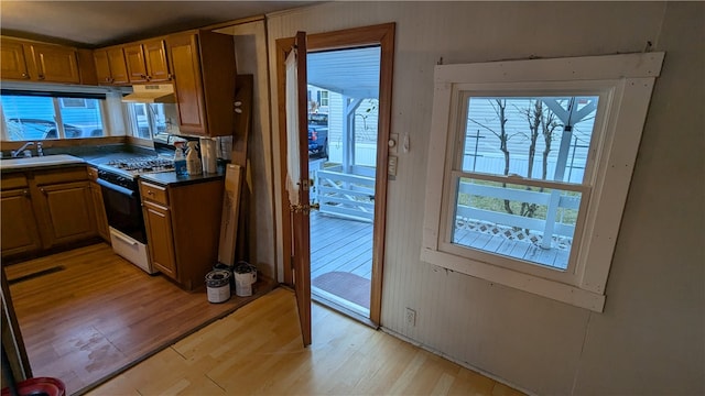 kitchen with white range with gas cooktop, sink, and light wood-type flooring