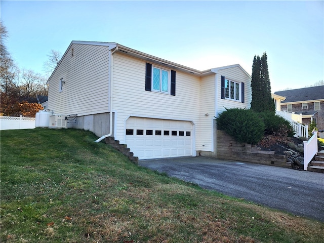 view of side of property featuring a garage and a lawn