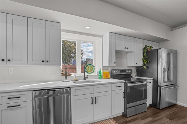 kitchen with white cabinets, sink, stainless steel appliances, and dark wood-type flooring