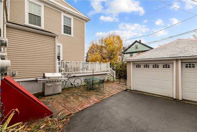 view of patio featuring a garage and an outbuilding