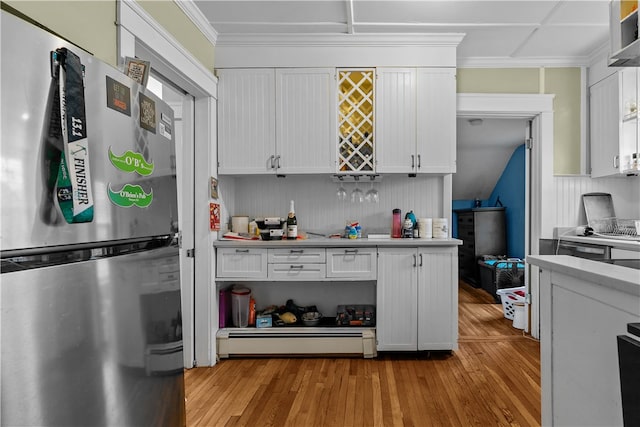 kitchen featuring stainless steel fridge, light wood-type flooring, baseboard heating, crown molding, and white cabinetry