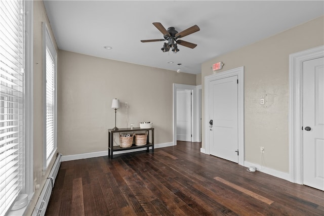 unfurnished bedroom with dark hardwood / wood-style floors, ceiling fan, and a baseboard heating unit