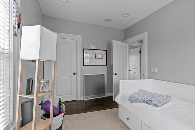 bedroom featuring multiple windows, a closet, and hardwood / wood-style floors