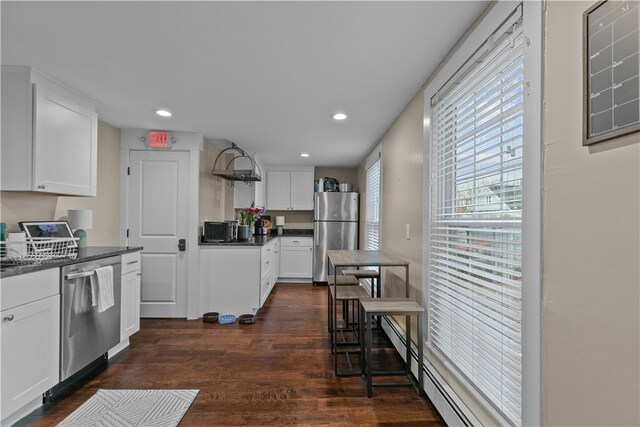 kitchen with white cabinets, appliances with stainless steel finishes, dark hardwood / wood-style flooring, and a baseboard radiator