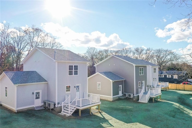 back of property featuring a deck and a lawn