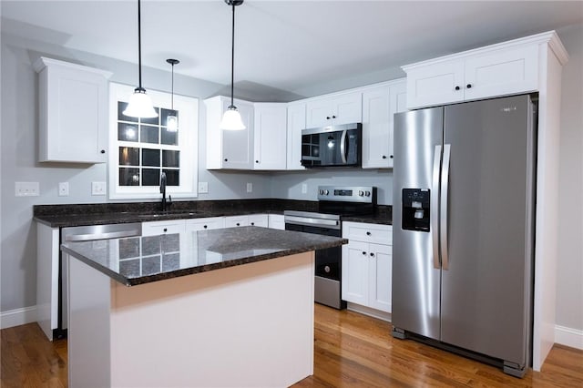 kitchen with sink, a kitchen island, dark hardwood / wood-style floors, and appliances with stainless steel finishes