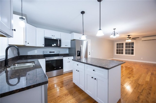 kitchen featuring white cabinets, sink, stainless steel appliances, and hanging light fixtures