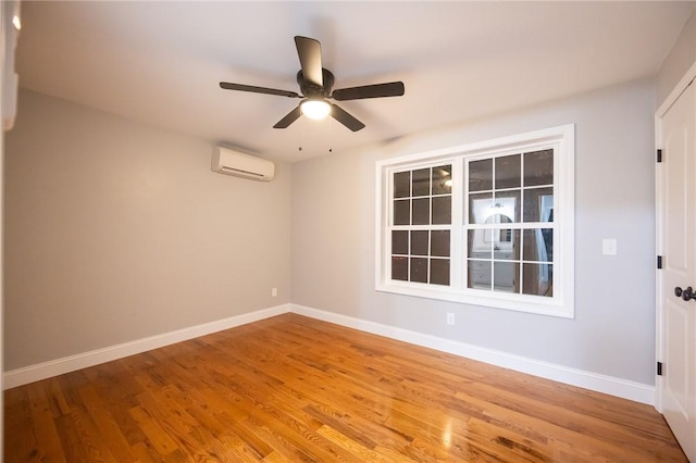 spare room featuring hardwood / wood-style floors, ceiling fan, and a wall mounted AC