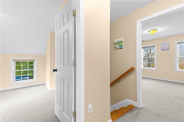 hallway with light carpet and lofted ceiling