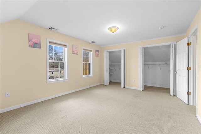 unfurnished bedroom with a closet, light colored carpet, and vaulted ceiling