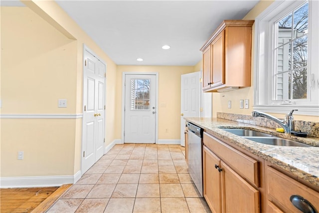 kitchen with dishwasher, light tile patterned floors, light stone countertops, and sink