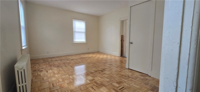 unfurnished room with radiator and light parquet floors