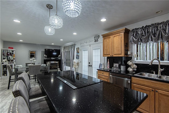 kitchen with sink, hanging light fixtures, stainless steel dishwasher, a chandelier, and black electric stovetop