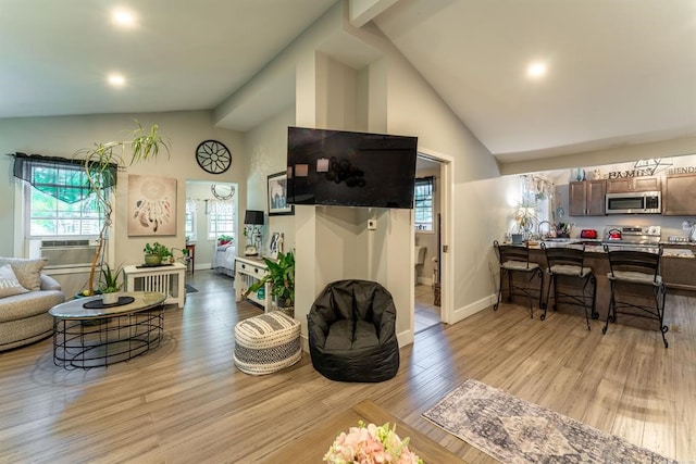 living room featuring high vaulted ceiling and light wood-type flooring