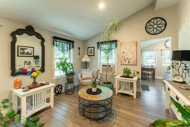 sitting room featuring wood-type flooring, vaulted ceiling, and cooling unit