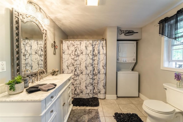 bathroom featuring tile patterned flooring, vanity, toilet, and stacked washer / dryer