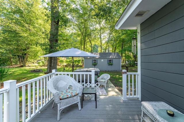 deck featuring an outbuilding and a yard