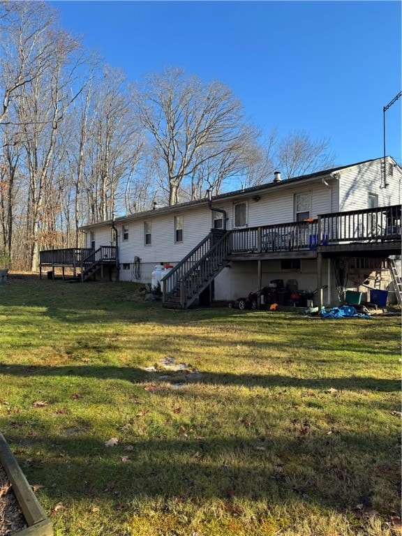 back of house featuring a yard and a wooden deck