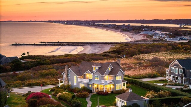 aerial view at dusk featuring a water view