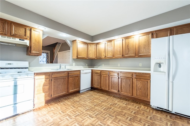 kitchen featuring white appliances, light parquet floors, and sink