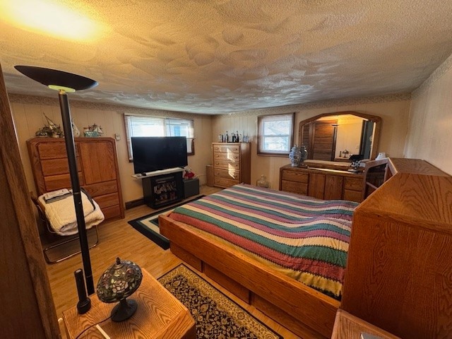 bedroom with light hardwood / wood-style floors and a textured ceiling