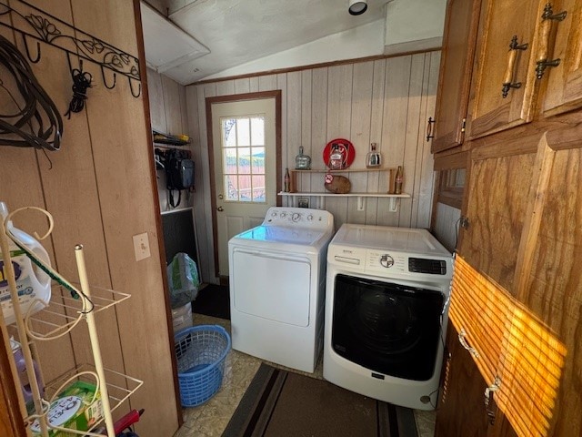 laundry area with cabinets, separate washer and dryer, and wooden walls