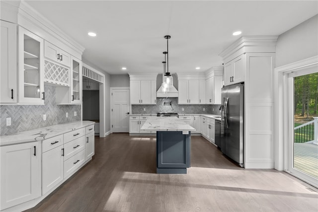 kitchen with white cabinets, stainless steel appliances, light stone counters, and dark hardwood / wood-style floors